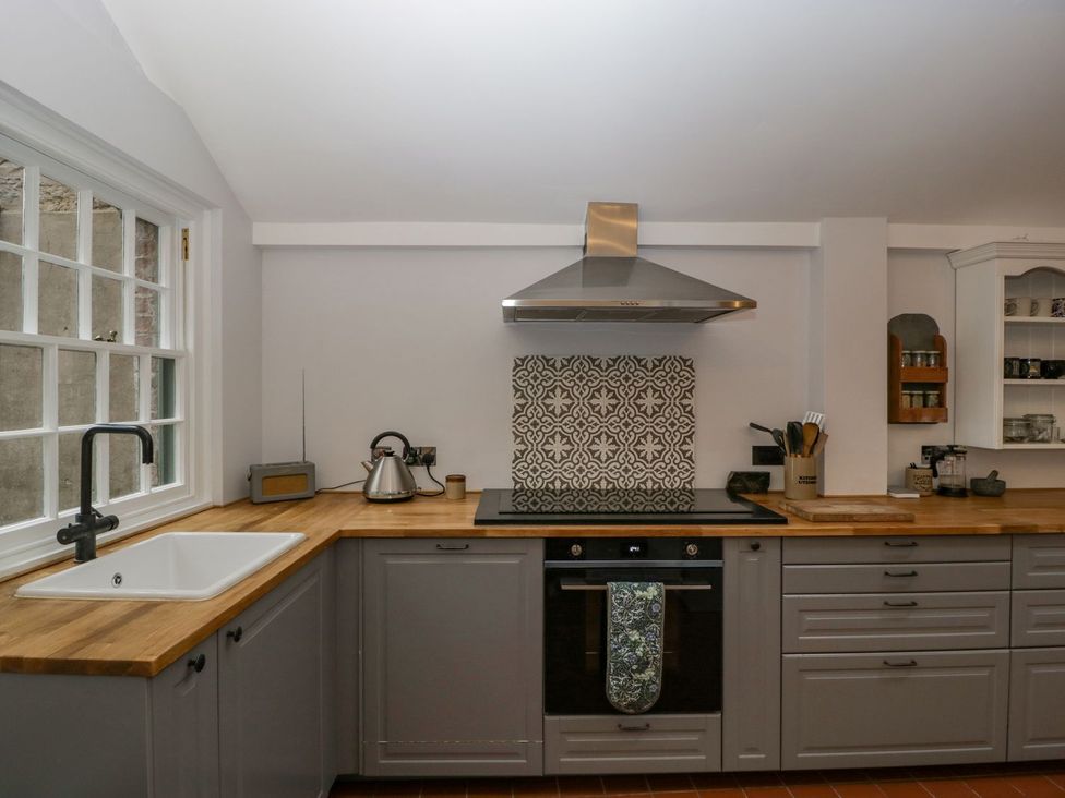 A kitchen with a stove and sink at Kylemore in Glastonbury