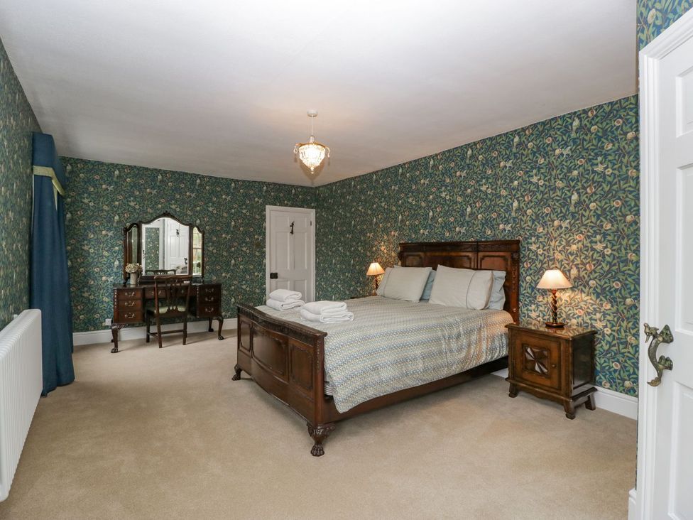 A bedroom with a bed and dressing table at Kylemore in Glastonbury