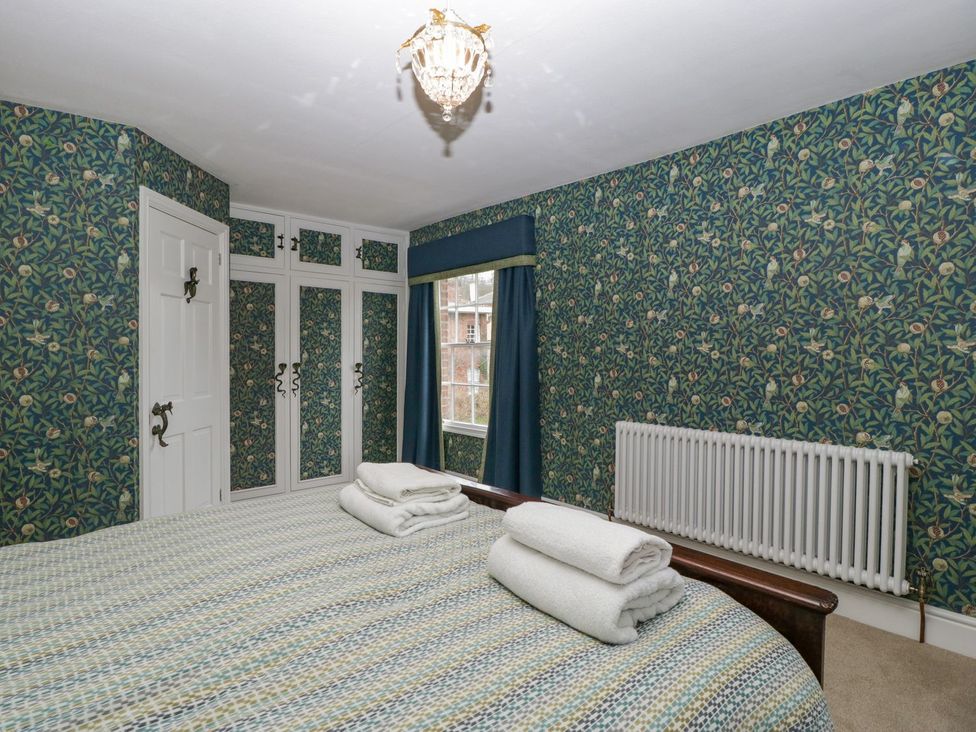 A bedroom with a bed and wardrobe at Kylemore in Glastonbury
