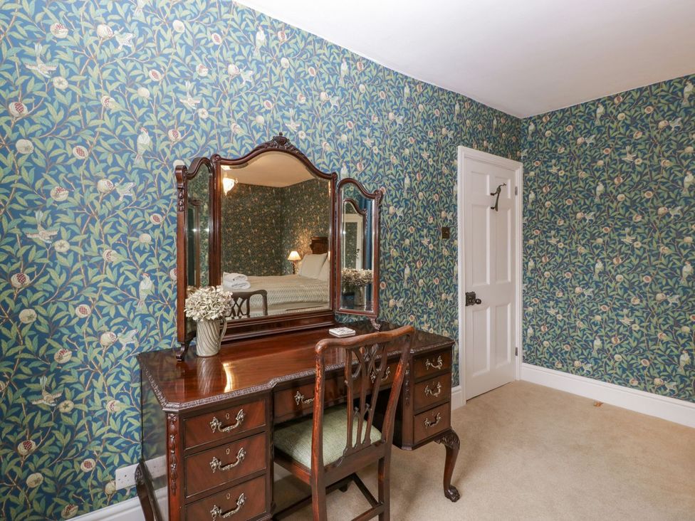 A bedroom with a vanity table and mirror at Kylemore in Glastonbury
