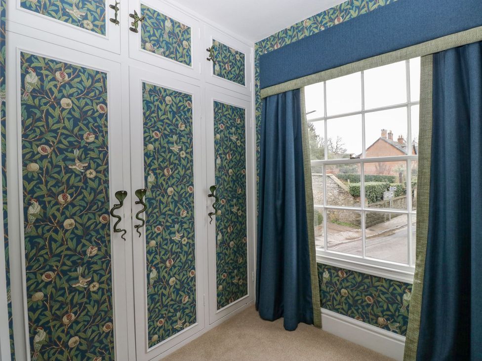 A bedroom with a wardrobe and window in Kylemore Glastonbury