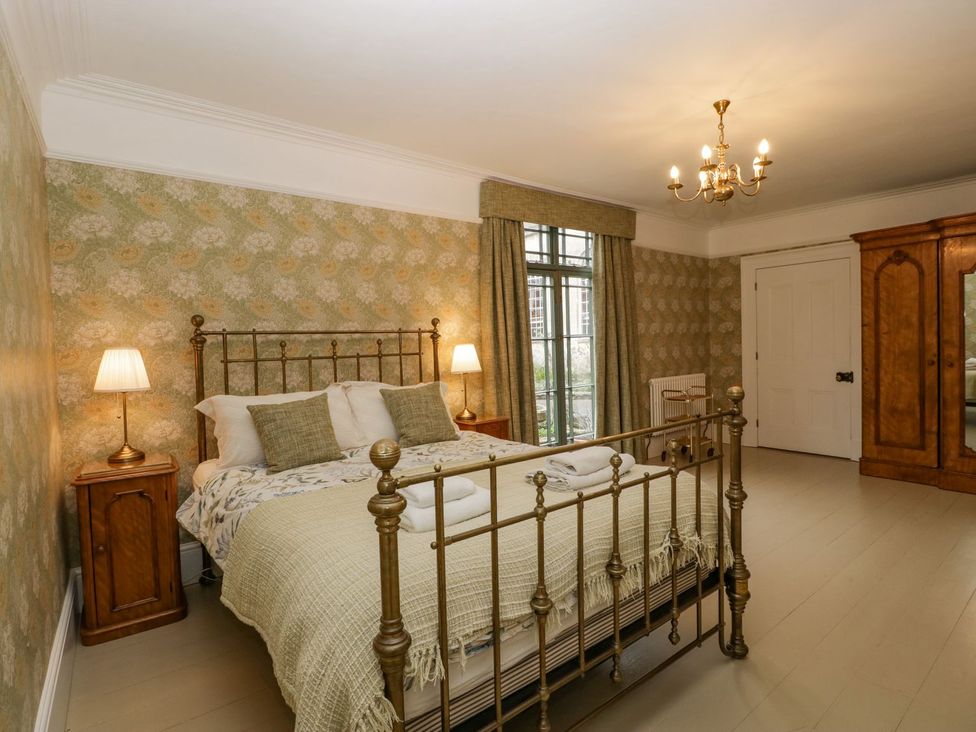 A bedroom with a bed and wardrobe at Kylemore in Glastonbury