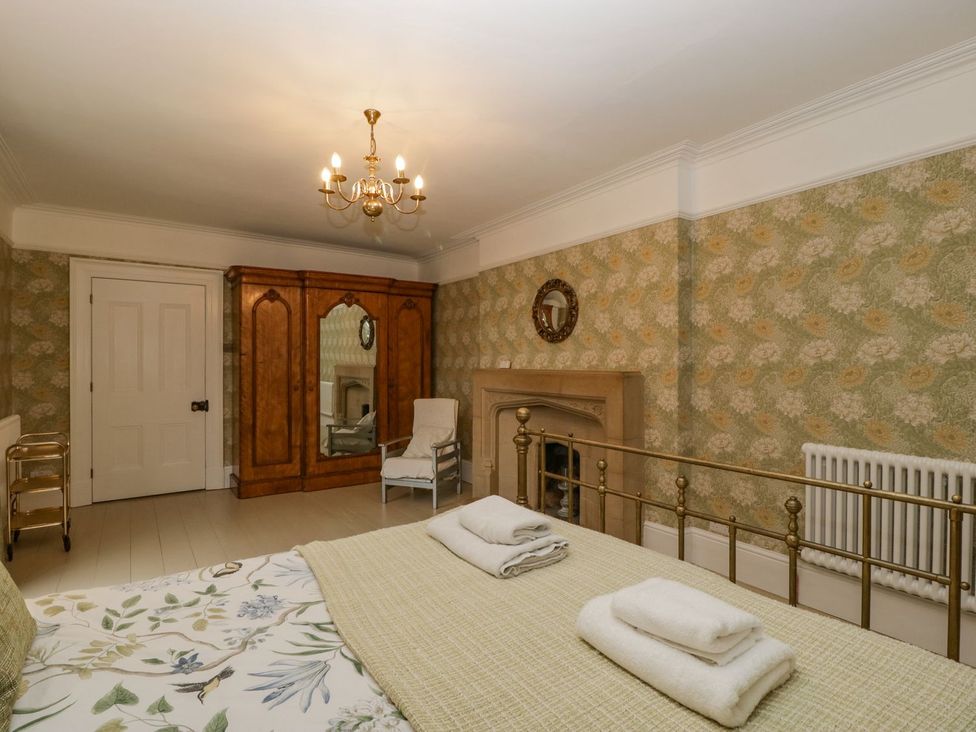 A bedroom with a bed and wardrobe at Kylemore in Glastonbury