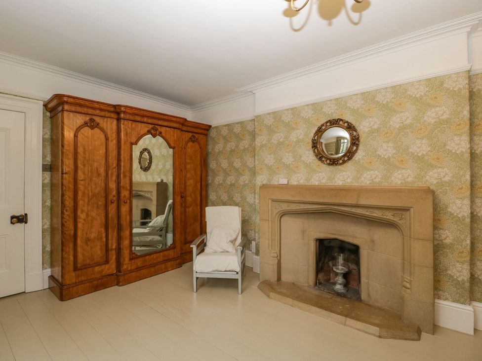 A living room with a wardrobe and mirror at Kylemore in Glastonbury