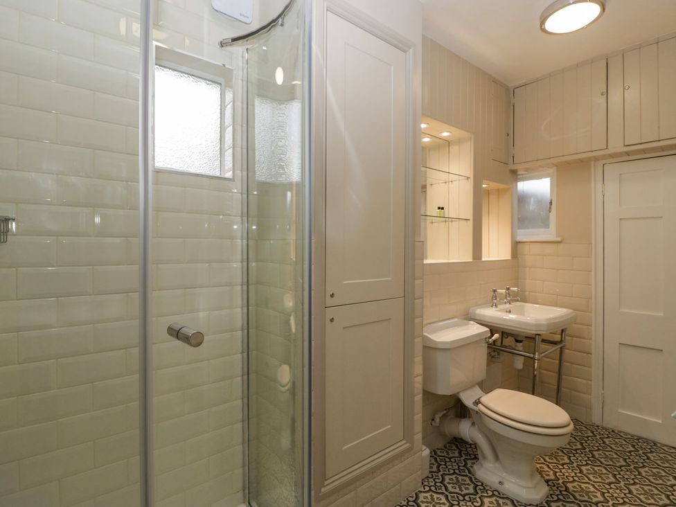 A bathroom with a shower, toilet, and sink at Kylemore in Glastonbury