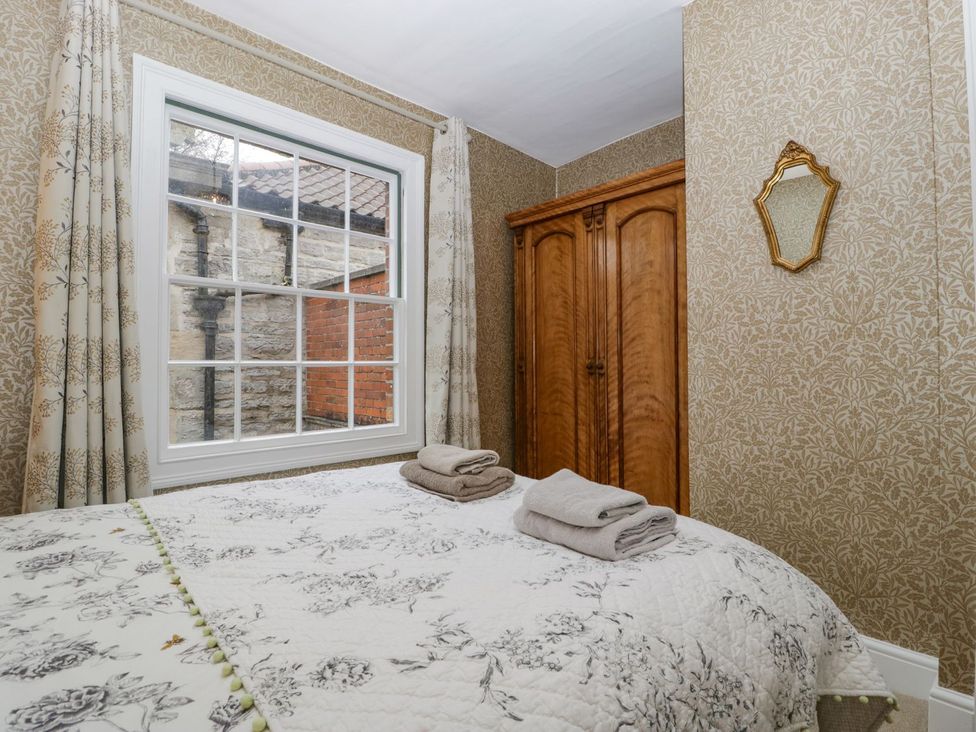 A bedroom with a bed and wardrobe at Kylemore in Glastonbury