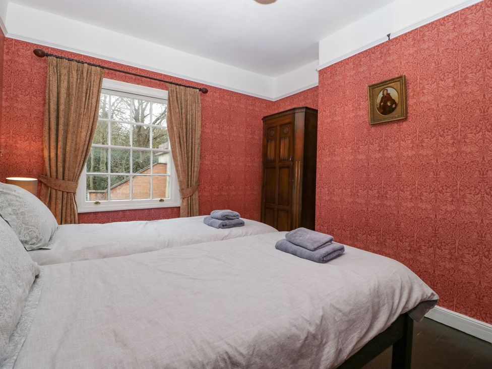 A bedroom with two beds and an armoire at Kylemore in Glastonbury