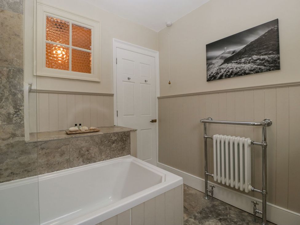 A bathroom with a bathtub and radiator at Kylemore in Glastonbury