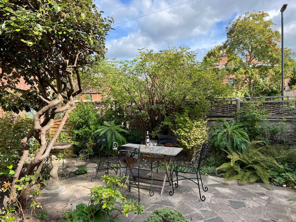 A garden with a table and chairs at Kylemore in Glastonbury
