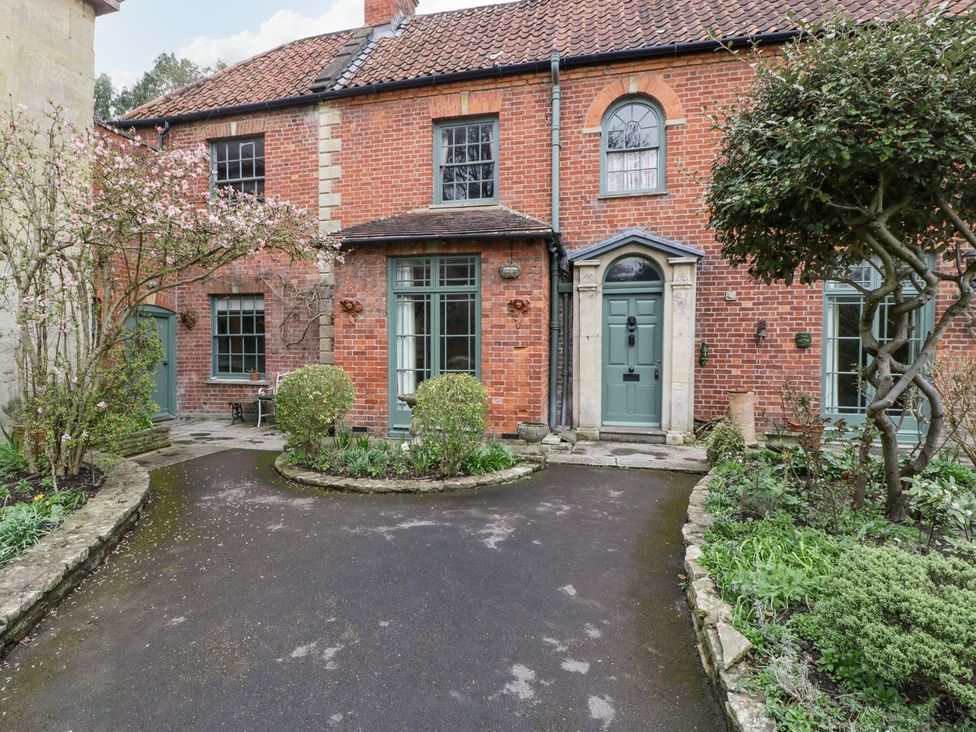 A brick house with a green door and pathway at Kylemore in Glastonbury