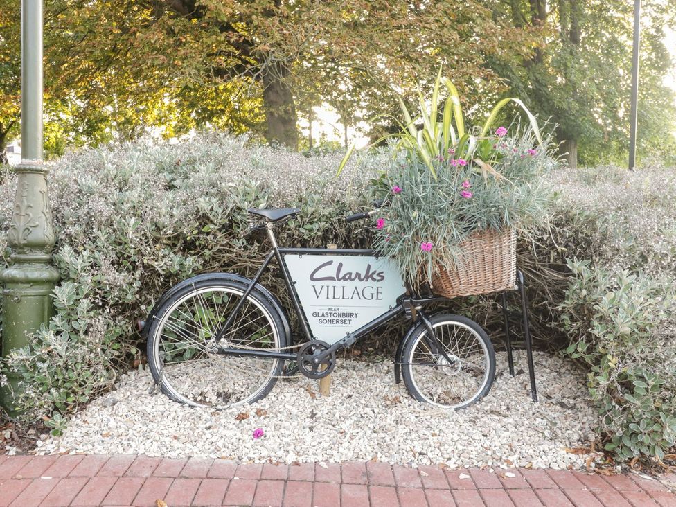A bicycle with a flower basket next to a sign at Clarks Village near Glastonbury