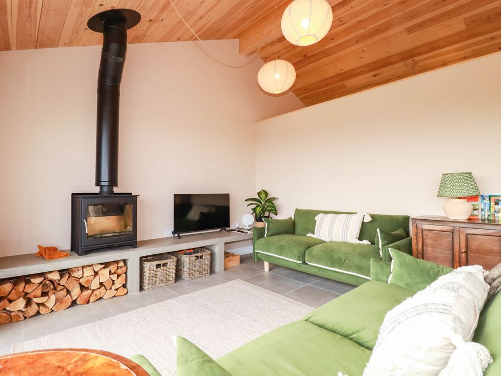 A living room with a wood stove and green sofa at Granfer’s