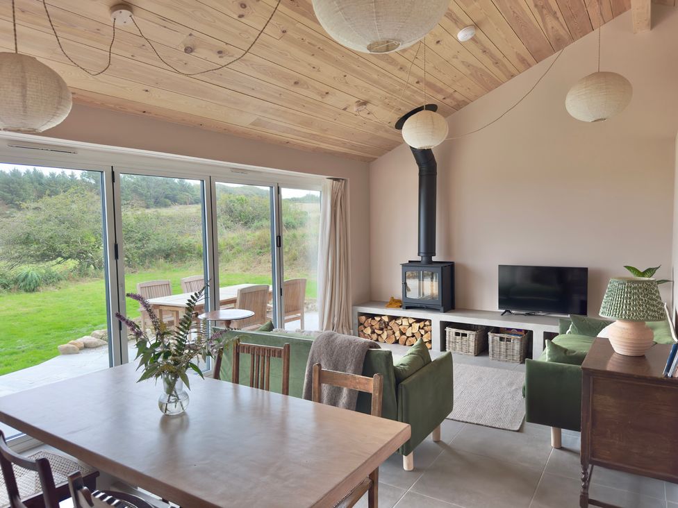 A living room with a table, chairs, and a wood stove at Granfer’s near Penryn
