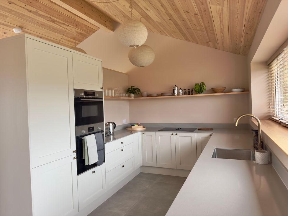A kitchen with cabinets, stove, oven, and sink at Granfer’s near Penryn