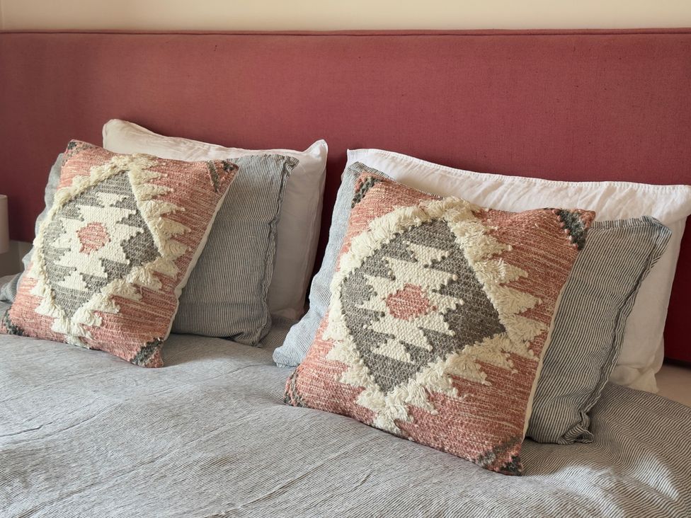 A bedroom with pillows and bedspread at Granfer’s near Penryn