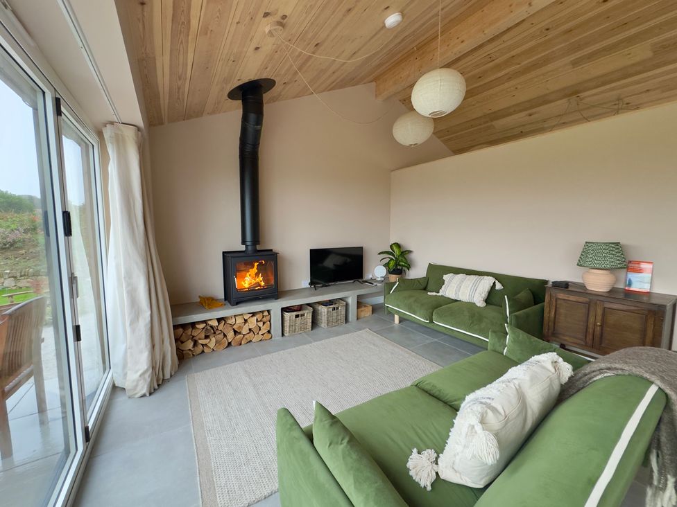 A living room with a fireplace, tv, and sofa at Granfer’s near Penryn
