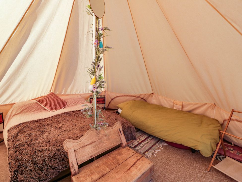 A tent interior with beds and a mirror at Bell Tent in Builth Wells