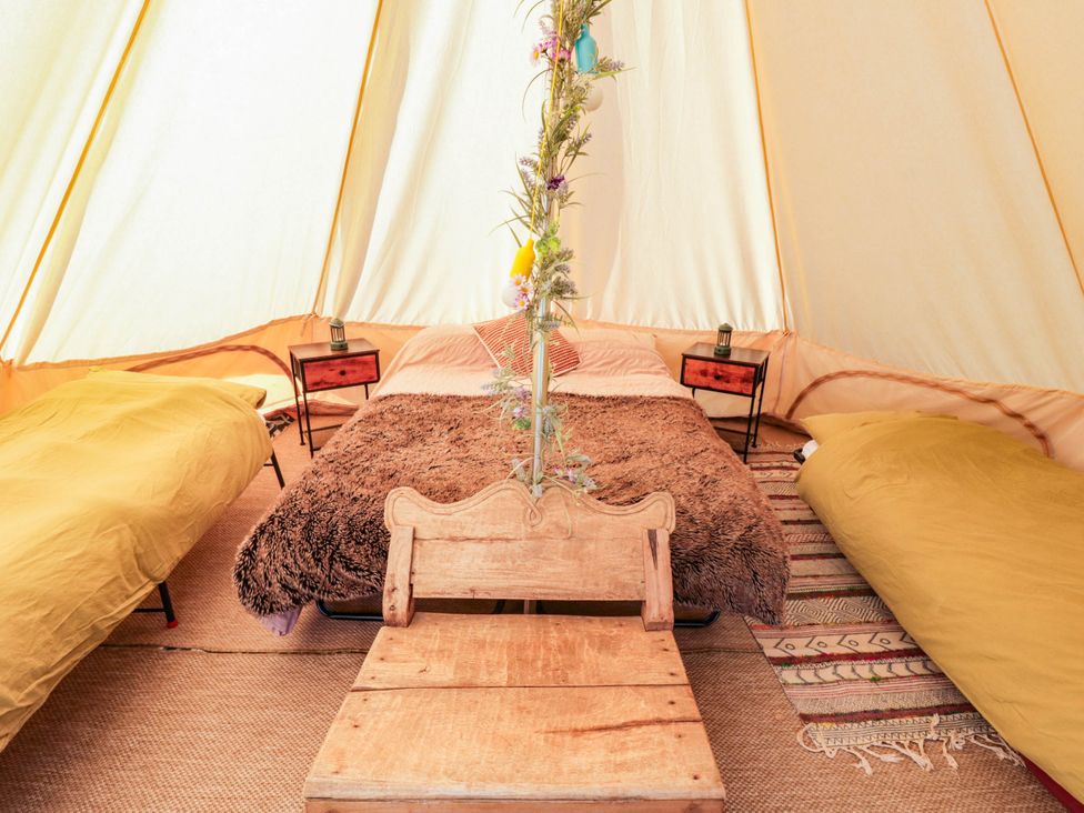 A bedroom with beds and side tables at Bell Tent in Builth Wells