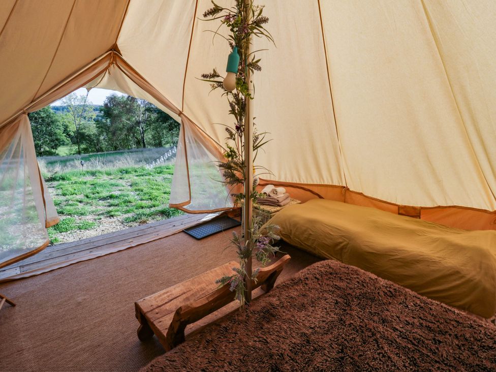A bedroom with beds and a wooden table at Bell Tent in Builth Wells
