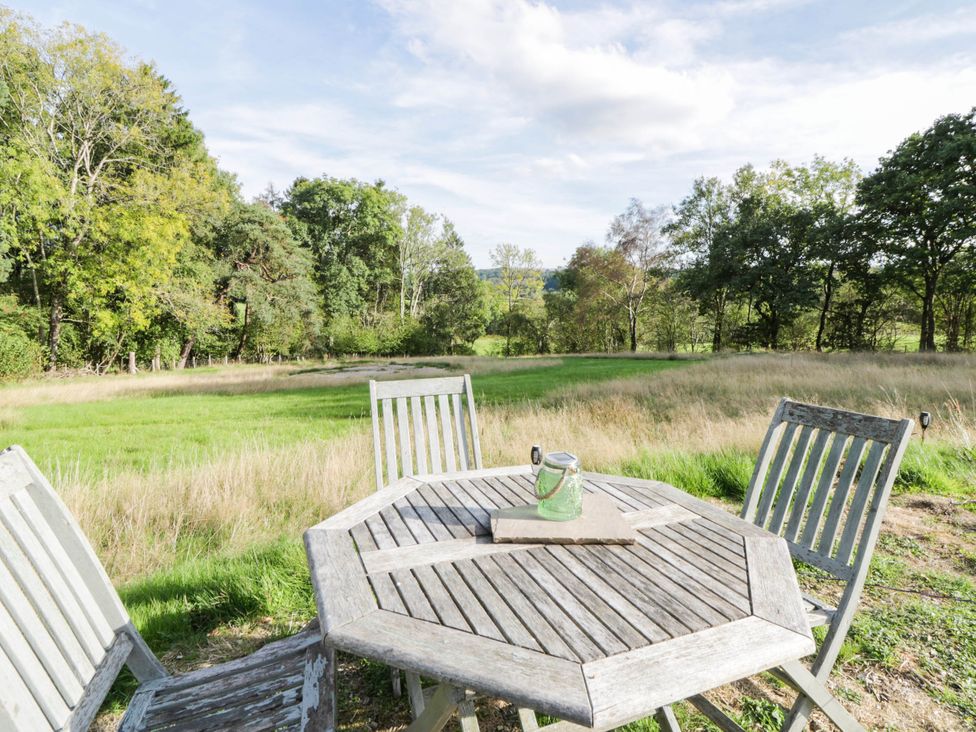 An outdoor seating area with a table and chairs at Bell Tent in Builth Wells