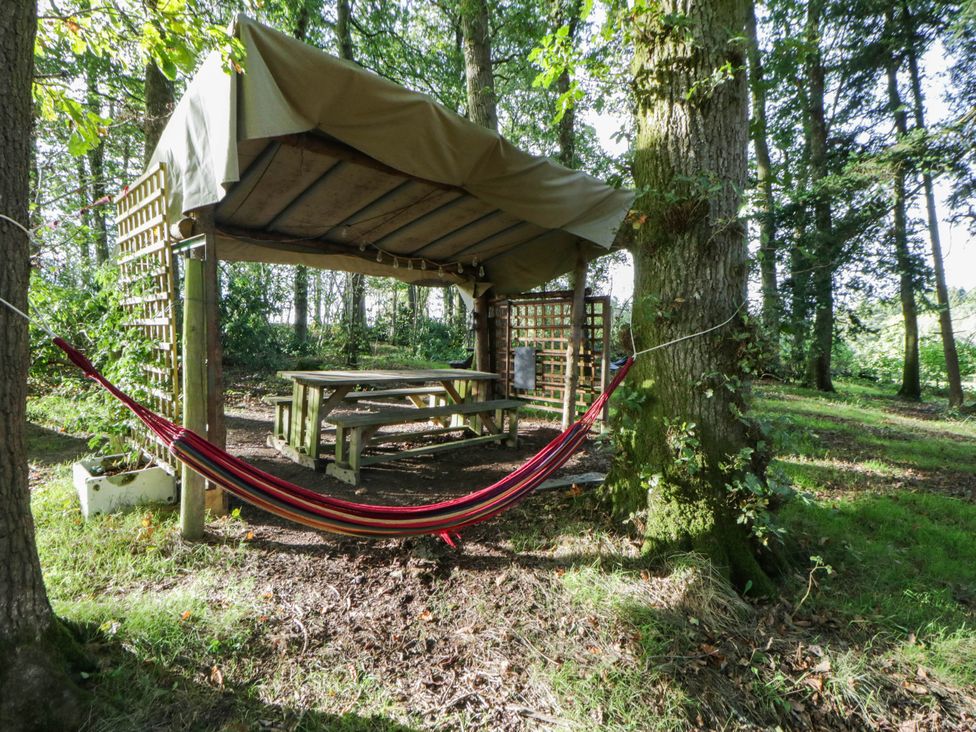 A garden with a hammock and picnic table at Bell Tent in Builth Wells