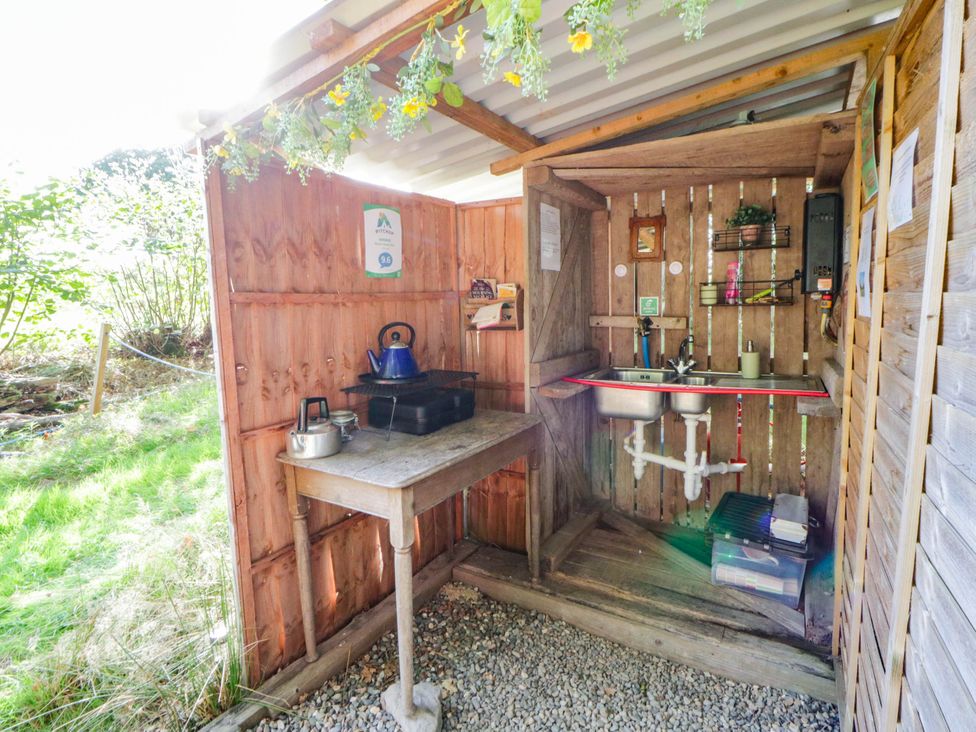 An outdoor kitchen with a sink and stove at Bell Tent in Builth Wells