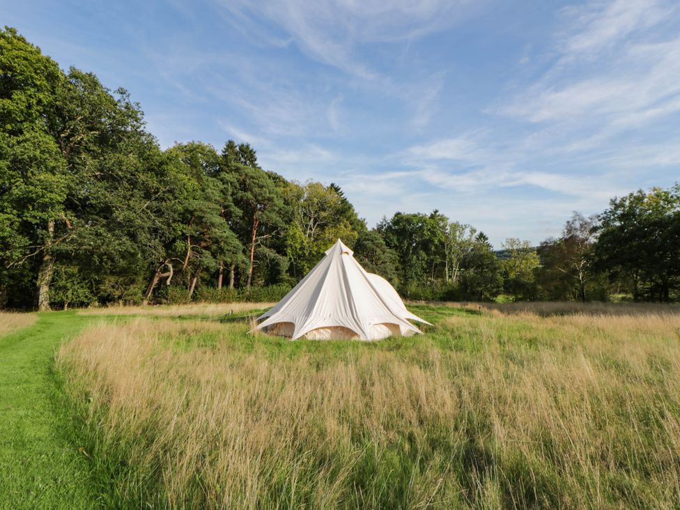 A bell tent in a field surrounded by trees at Bell Tent in Builth Wells