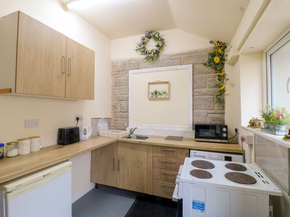 A kitchen with appliances and counter space at Greystones Apartment A near Buxton