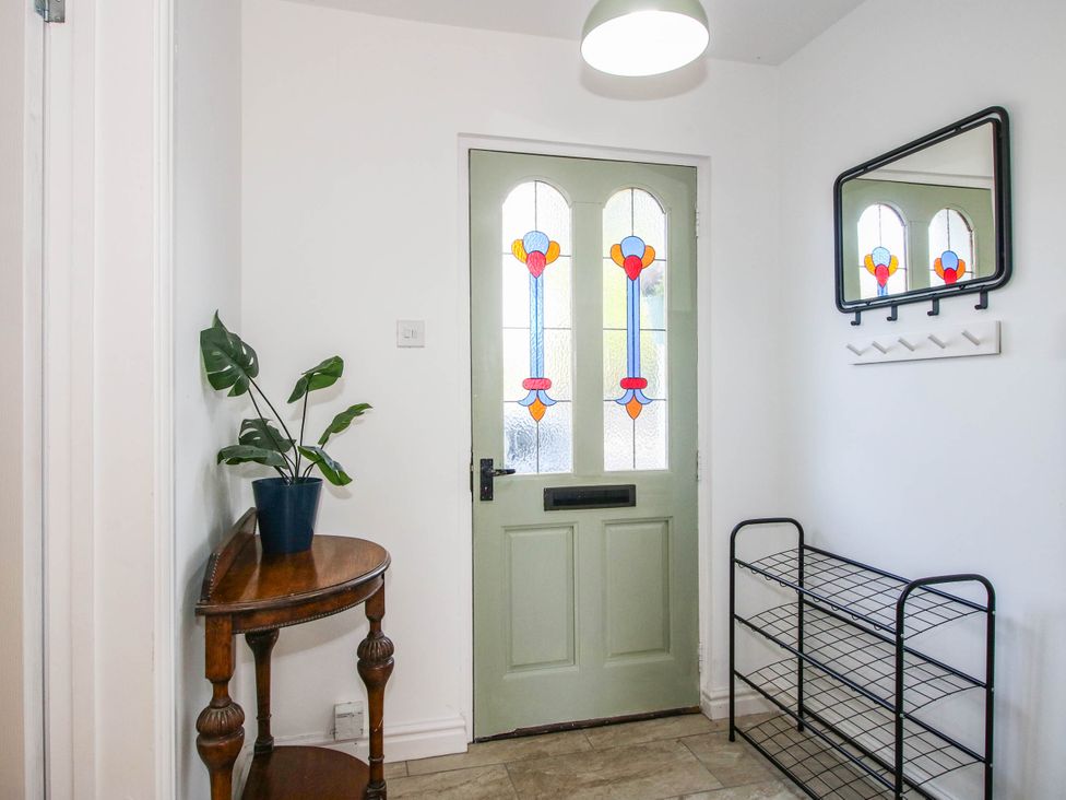 A hallway with a green door and a plant at 3 Jubilee Cottages in Pontesbury