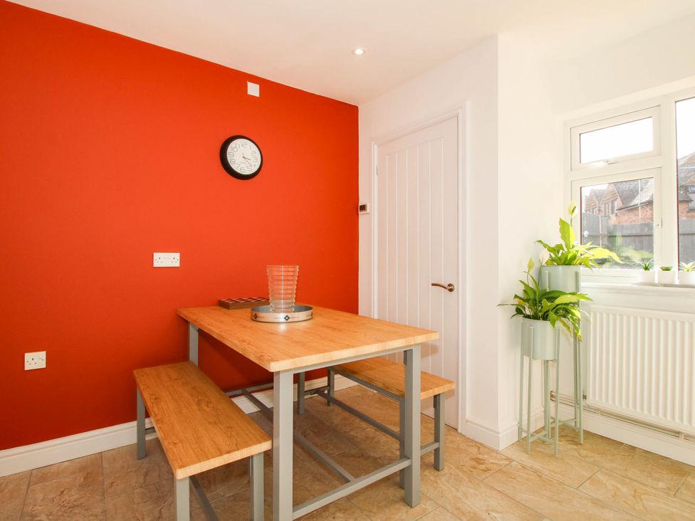 A dining table with benches and a clock at 3 Jubilee Cottages Pontesbury