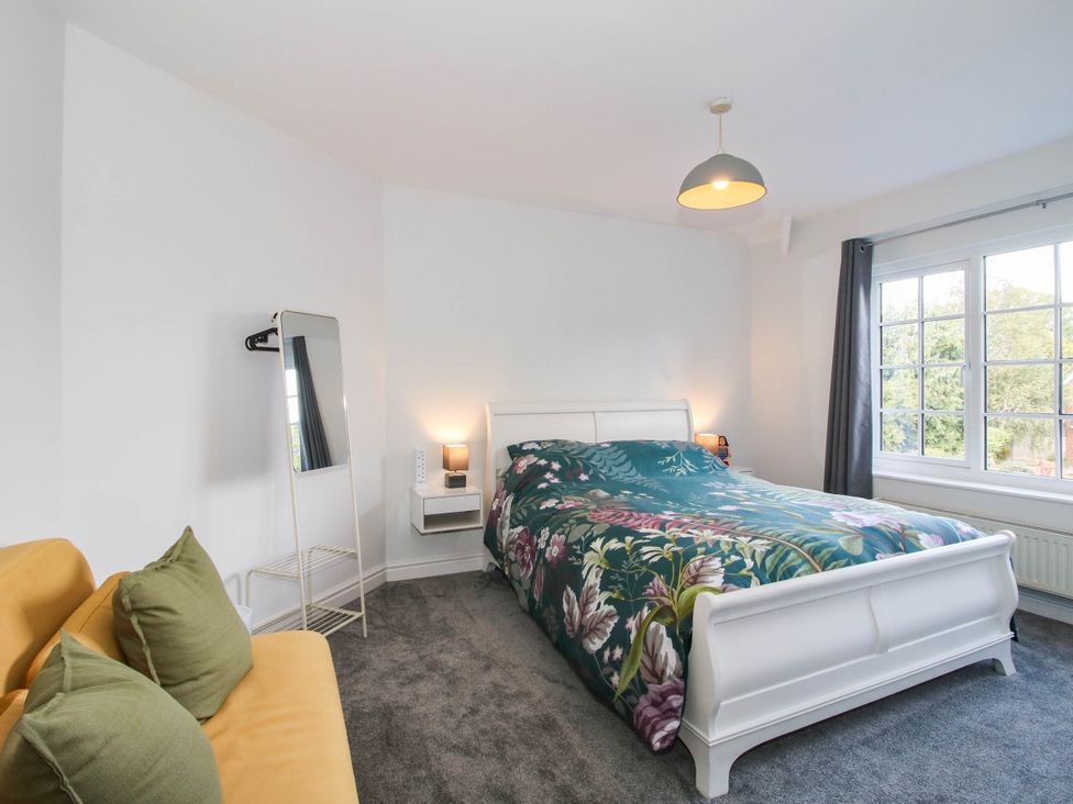 A bedroom with a bed and mirror at 3 Jubilee Cottages in Pontesbury