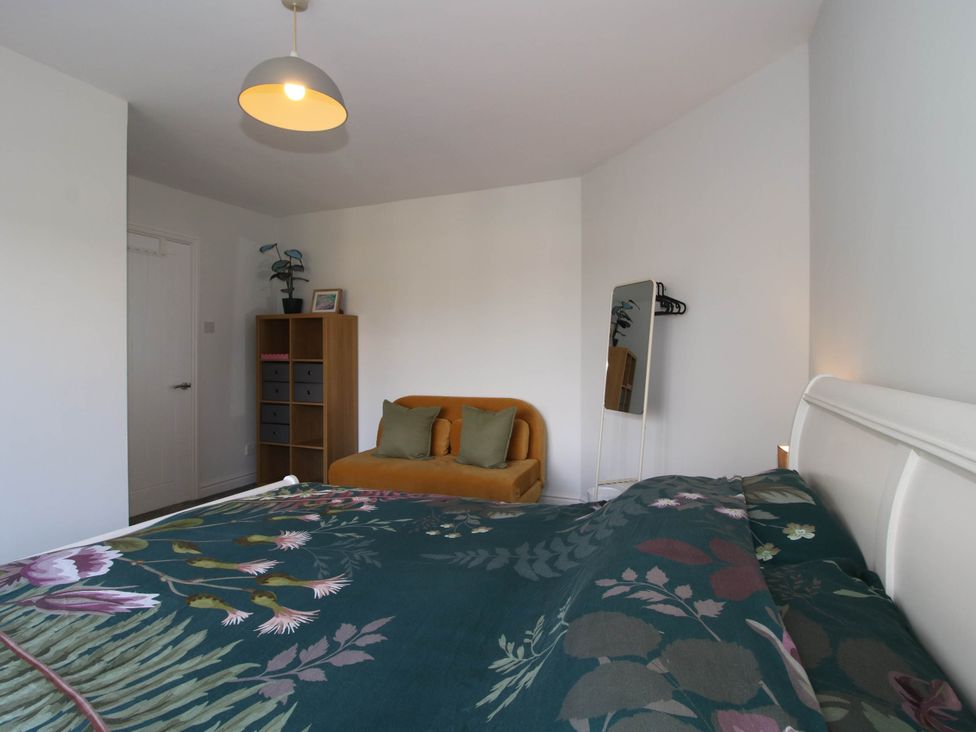 A bedroom with a bed and a sofa at 3 Jubilee Cottages in Pontesbury