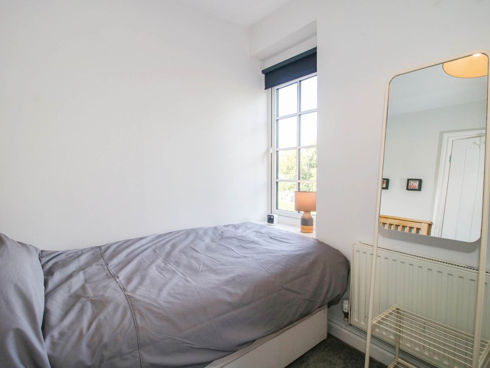 A bedroom with a bed and lamp at 3 Jubilee Cottages in Pontesbury