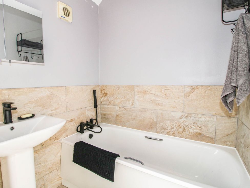 A bathroom with a bathtub and sink at 3 Jubilee Cottages Pontesbury