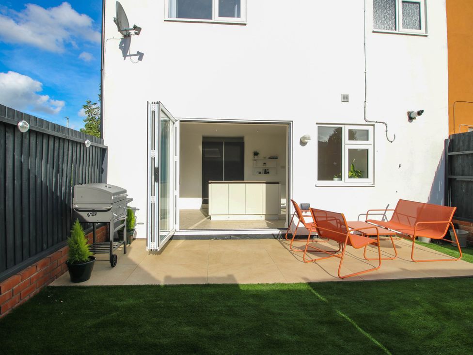 A garden with seating and a grill at 3 Jubilee Cottages Pontesbury
