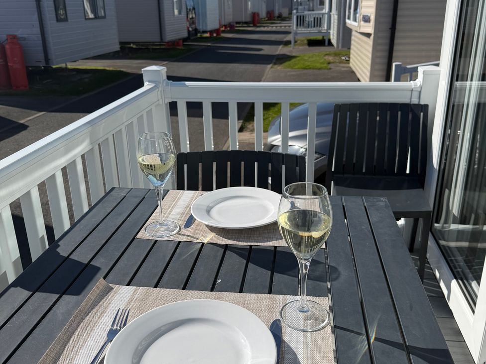 An outdoor dining area with a table set for two at Cala Gran - The Retreat 256 Boundary Road, Fleetwood