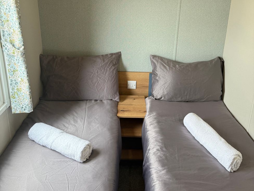 A bedroom with two single beds and a nightstand at Cala Gran - The Retreat 256 Boundary Road, Fleetwood