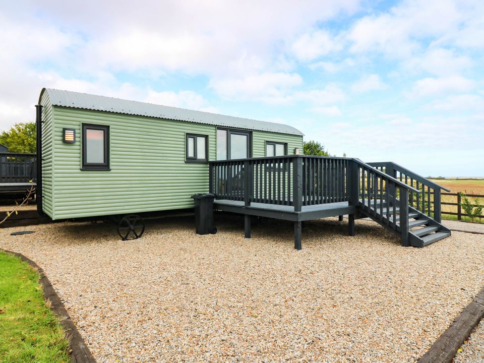 A static caravan with a deck and steps at Calendonia Hut West Mains near Haggerston