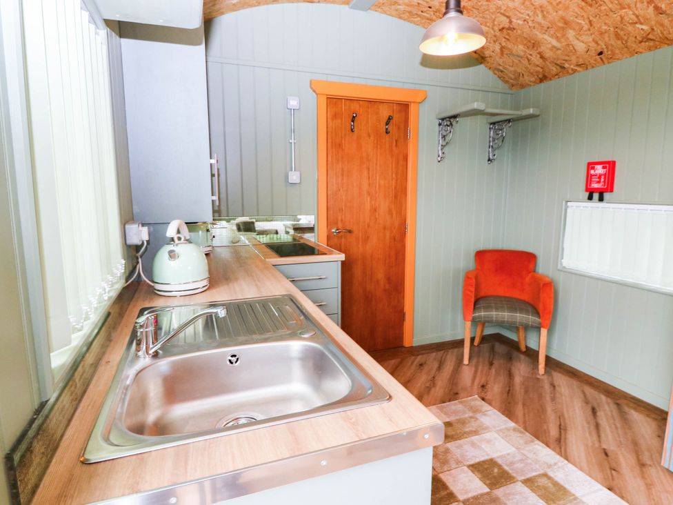 A kitchen with a sink and chair at Calendonia Hut in West Mains near Haggerston