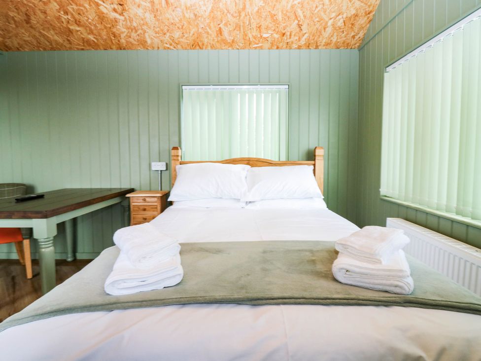 A bedroom with a bed and a table at Calendonia Hut, West Mains near Haggerston