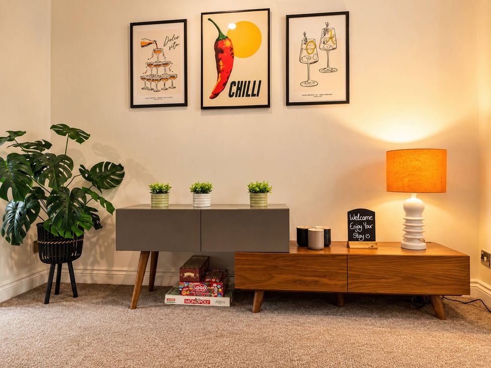 A living room with a side table and plants at 20A Westend Parade in Gloucester