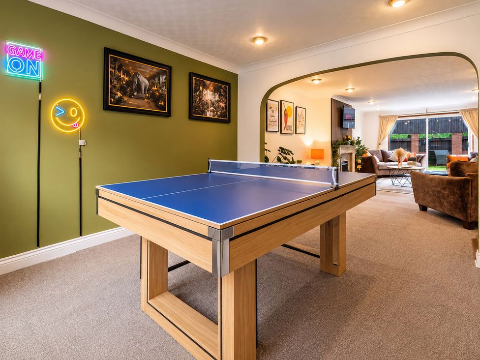 A recreation room with a ping pong table and seating area at 20A Westend Parade in Gloucester