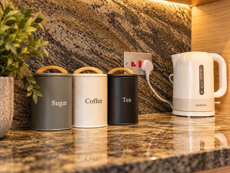 Three canisters for sugar, coffee, and tea with a kettle in a kitchen at 20A Westend Parade in Gloucester