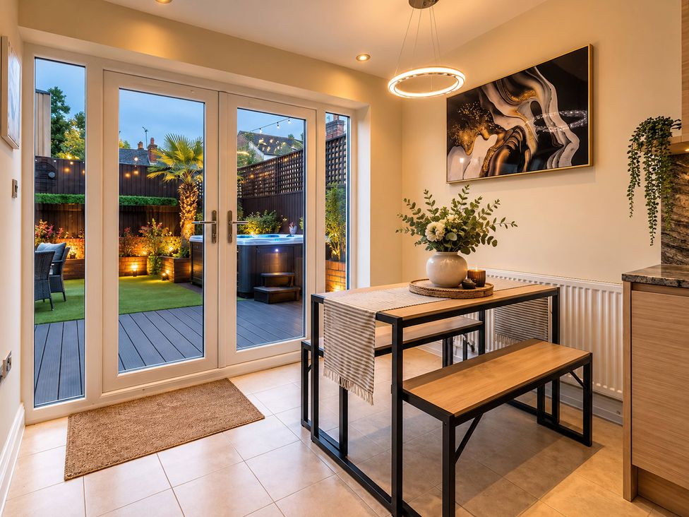 A dining room with a table and bench leading to a garden at 20A Westend Parade in Gloucester