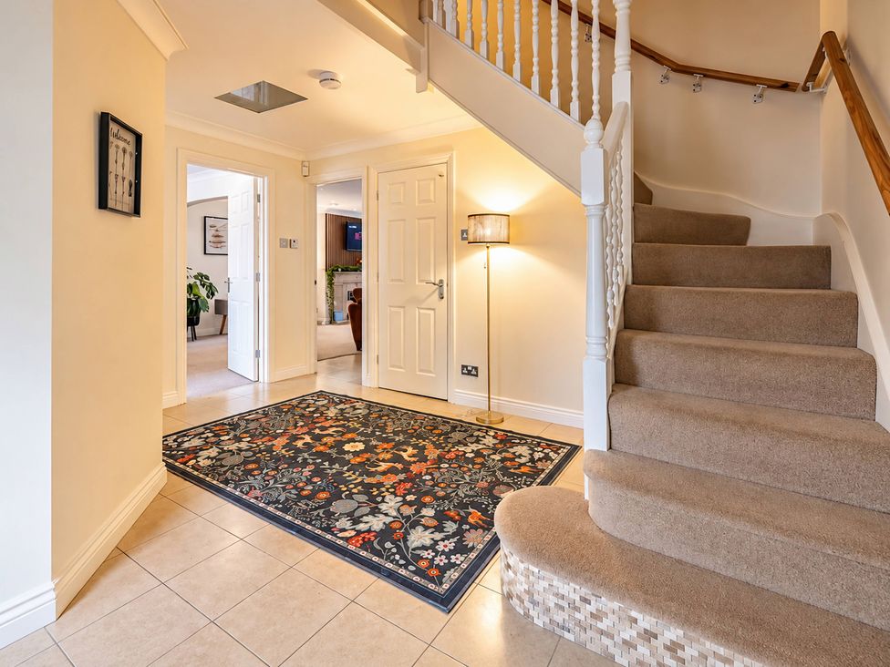 A hallway with staircase and rug at 20A Westend Parade in Gloucester
