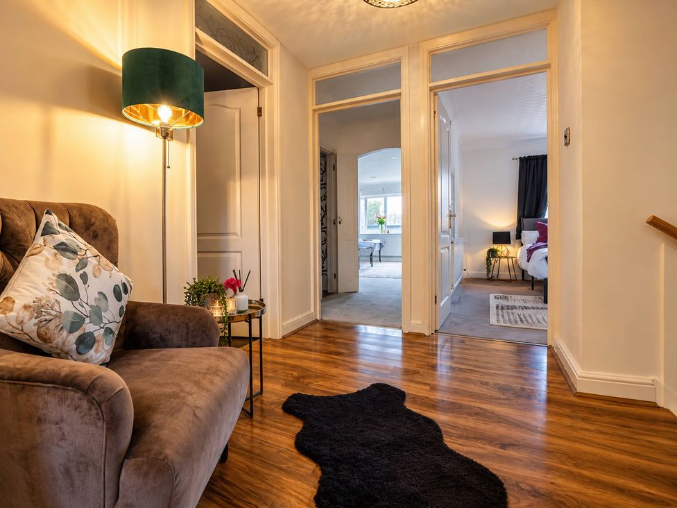 A hallway with a sofa and lamp at 20A Westend Parade in Gloucester