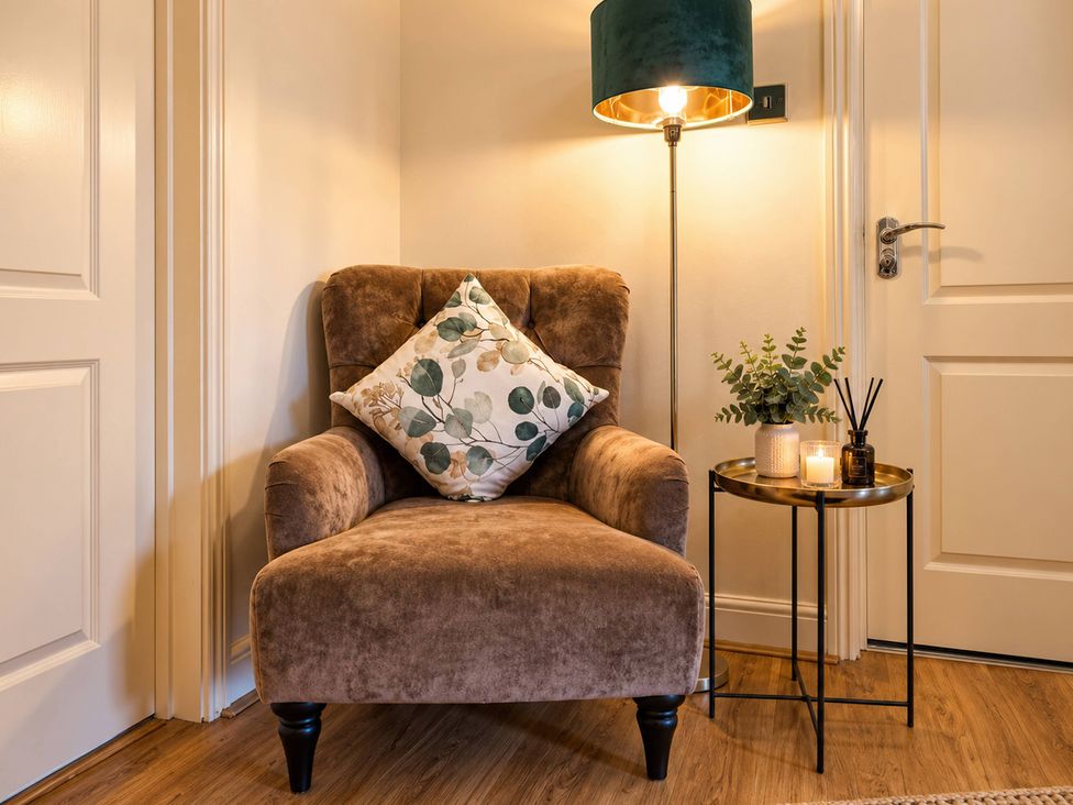 A living room with an armchair and lamp at 20A Westend Parade in Gloucester