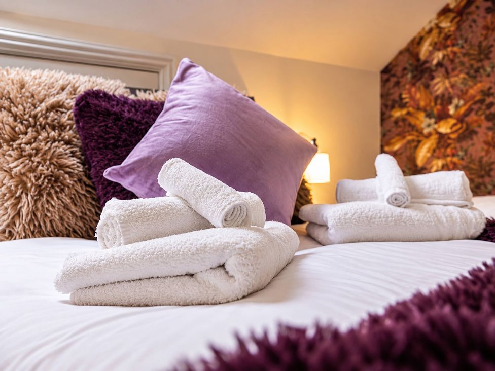 A bedroom with towels and pillows on the bed at 20A Westend Parade in Gloucester
