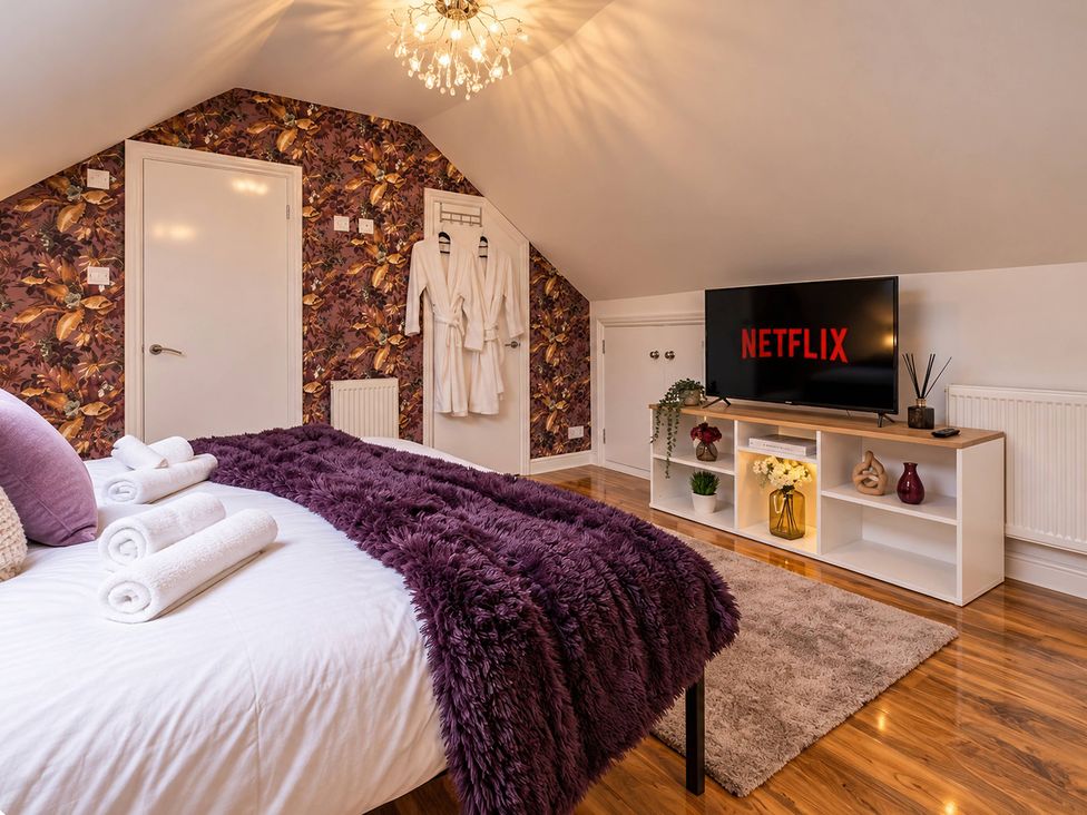 A bedroom with a bed and a television at 20A Westend Parade, Gloucester