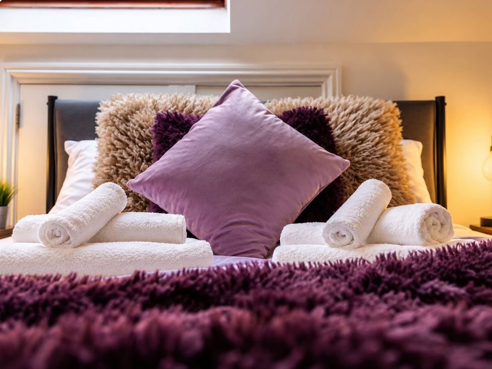 A bedroom with a bed and towels arranged on it at 20A Westend Parade in Gloucester